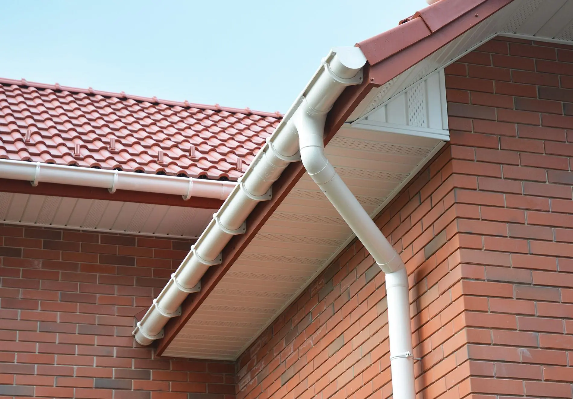 UPVC fascia and soffits London installer fitting new gutters along a roofline