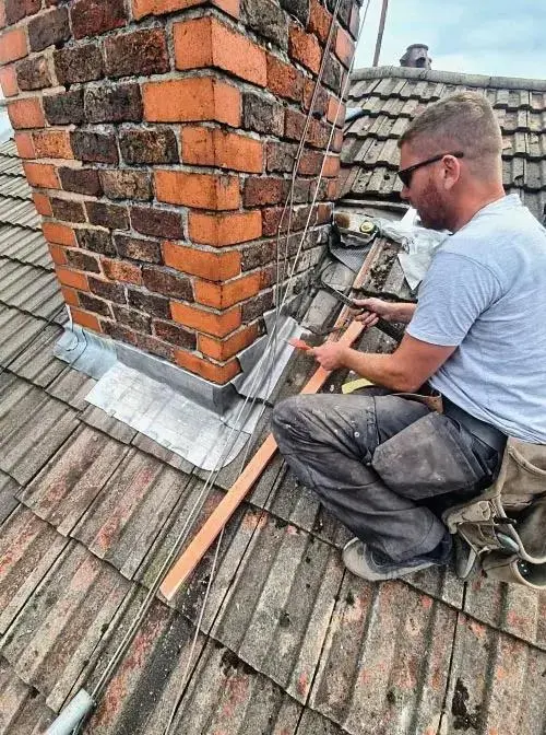 chimney repair London mason repointing brick mortar on a rooftop stack