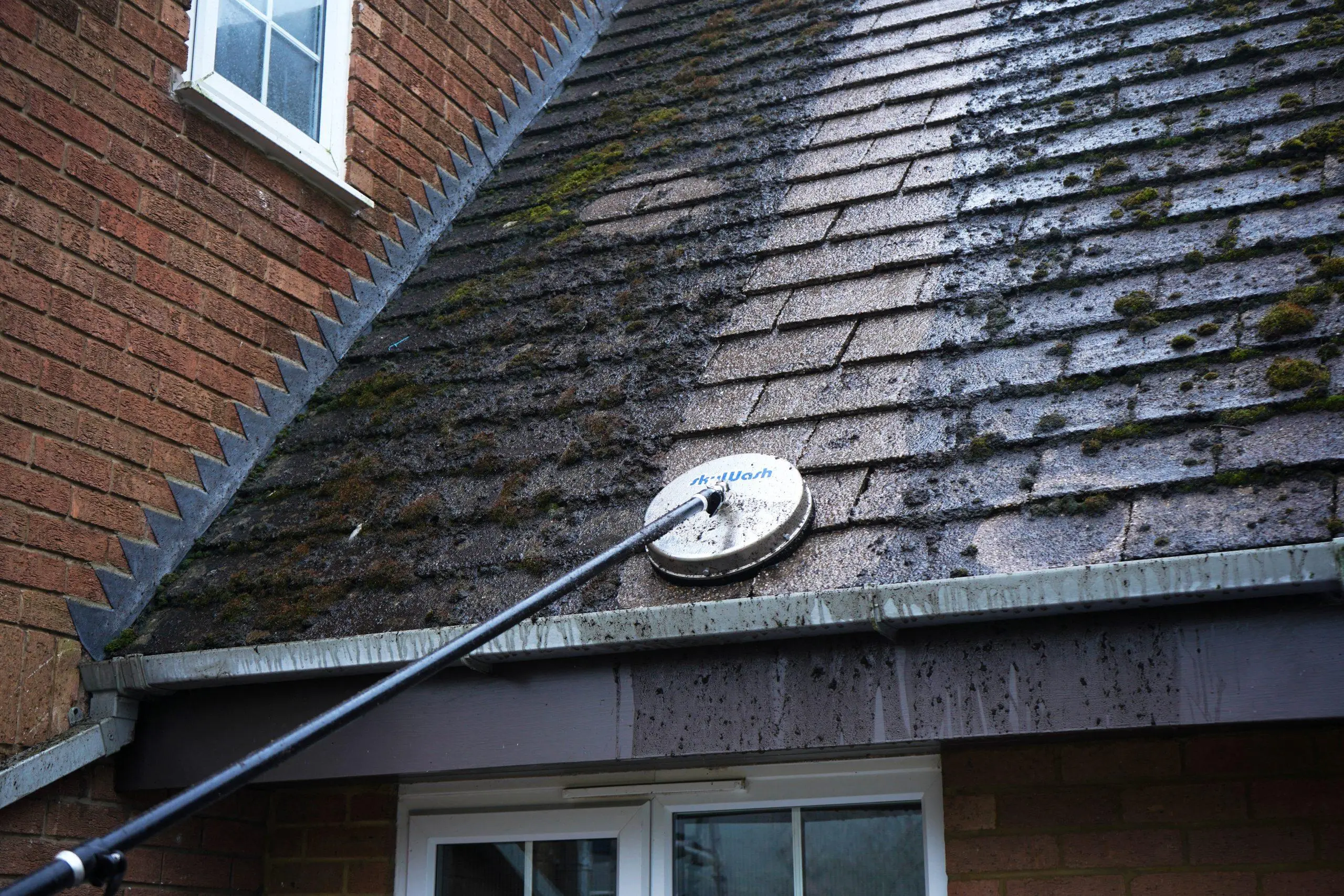 moss removal roof London soft-wash treatment being sprayed across roof tiles