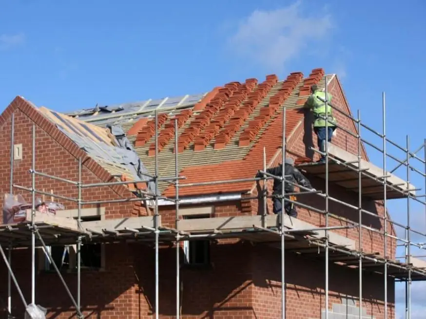 new roof installation London team fitting tiles on a residential roof