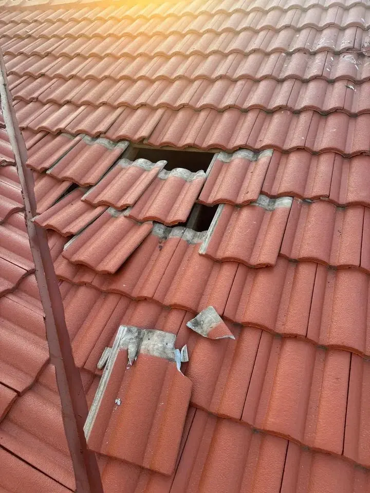 tiled roof repair London worker fitting a new clay tile into place